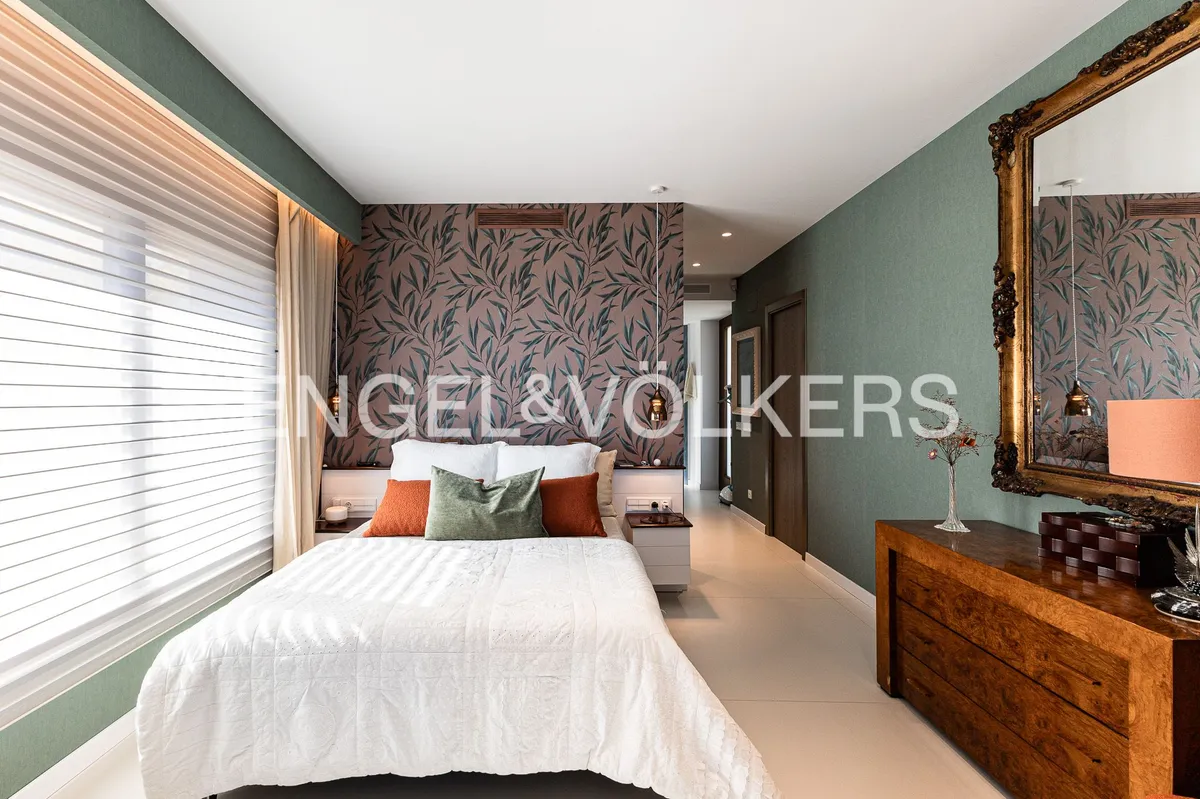 Dormitorio de una casa en Sant Pol de Mar con papel pintado decorativo, mobiliario de madera y diseño contemporáneo.