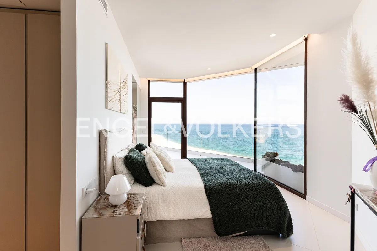Dormitorio principal de una casa en Sant Pol de Mar con ventanales de suelo a techo y vistas panorámicas al Mediterráneo.