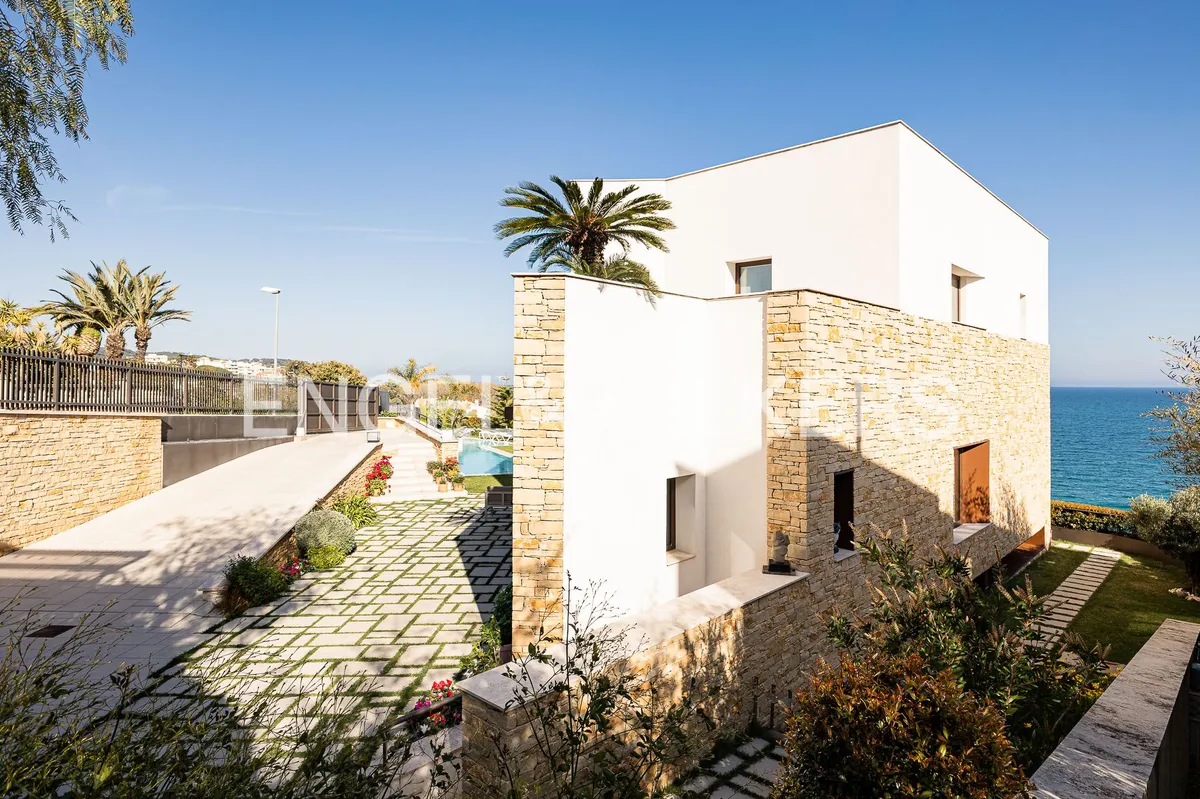 Fachada de una casa en Sant Pol de Mar con piedra natural, jardín y vistas al Mediterráneo.