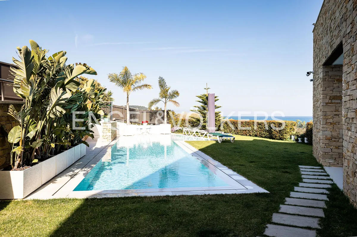 Piscina climatizada y jardín de una casa en Sant Pol de Mar con vistas al Mediterráneo.