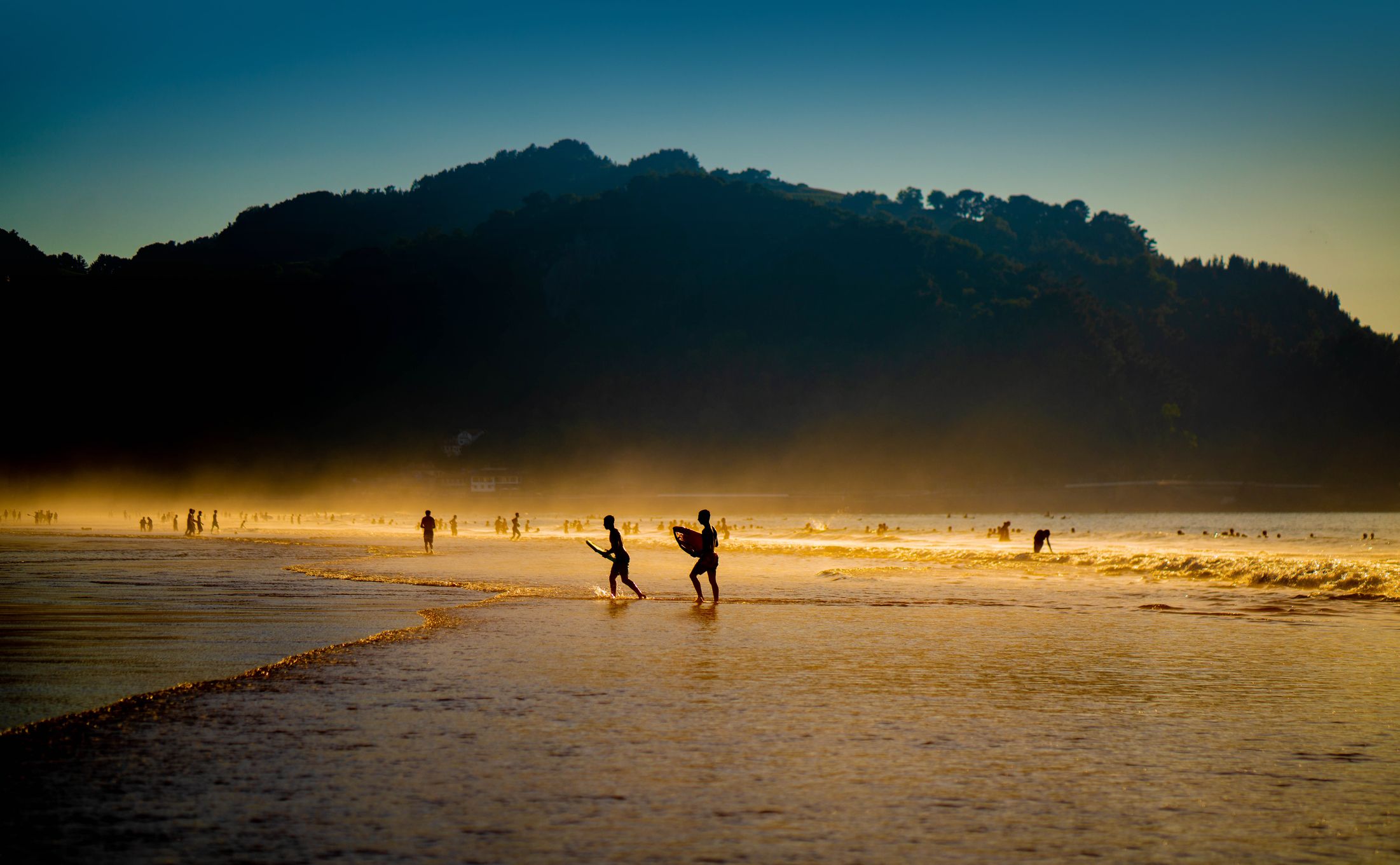 Surfistas en la playa de Zarautz (Gipuzkoa), una de las mejores playas para hacer surf en España al atardecer.