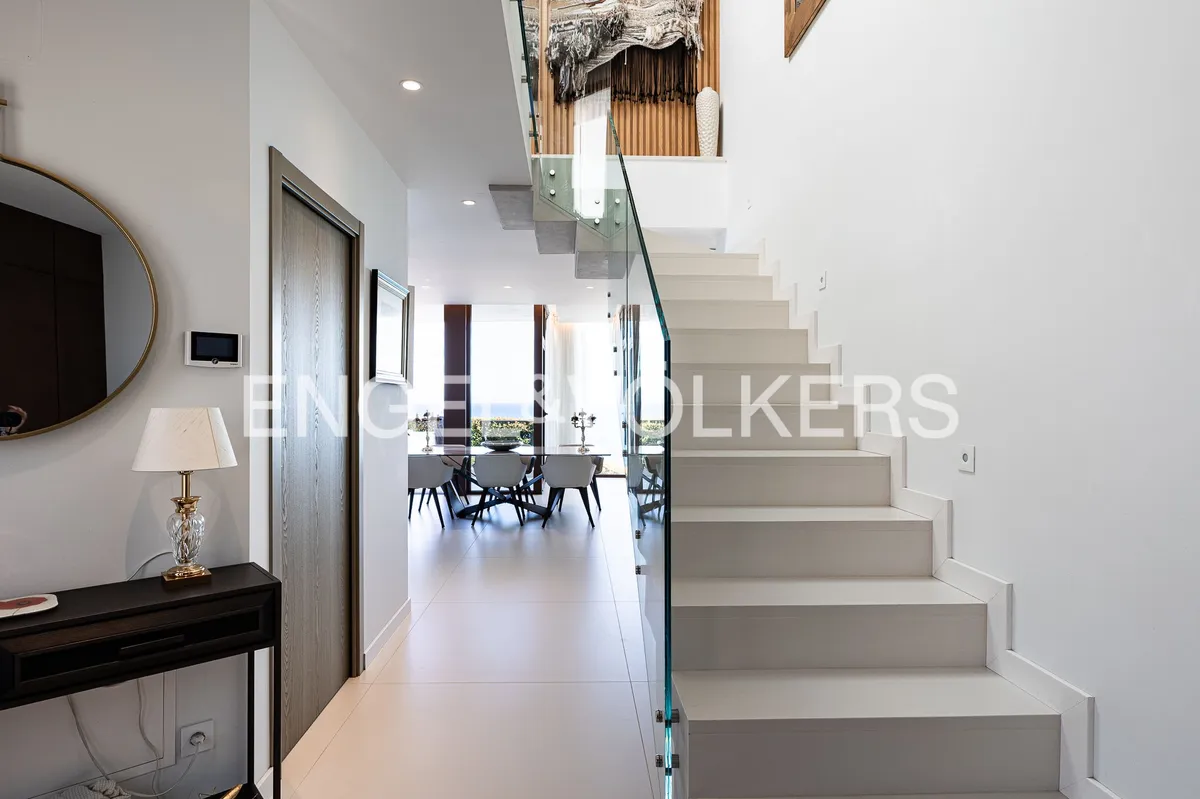 Recibidor de una casa en Sant Pol de Mar con escalera de diseño contemporáneo y espacios abiertos llenos de luz natural.