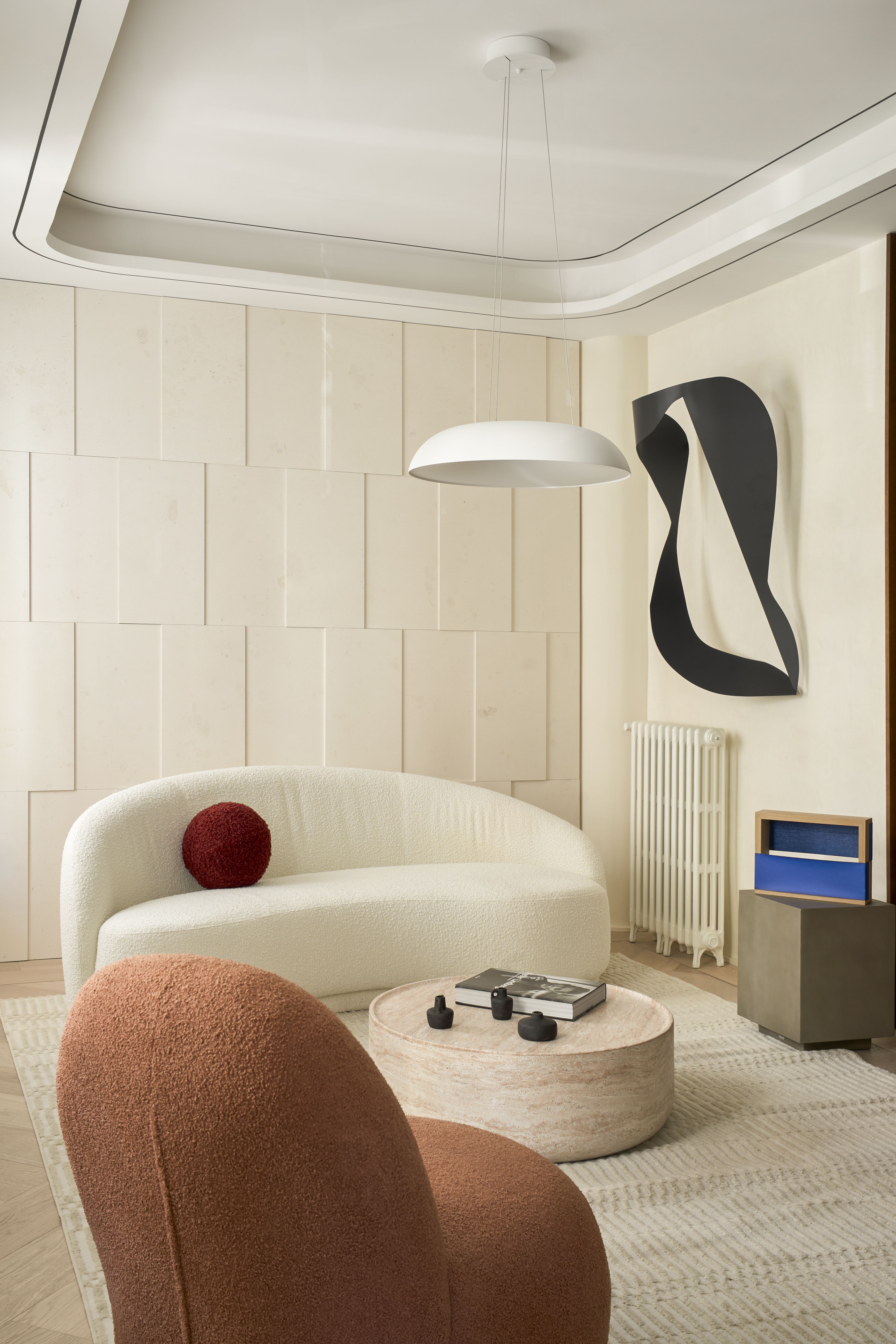 Salón contemporáneo con sofá curvo, madera natural y tonos cálidos.