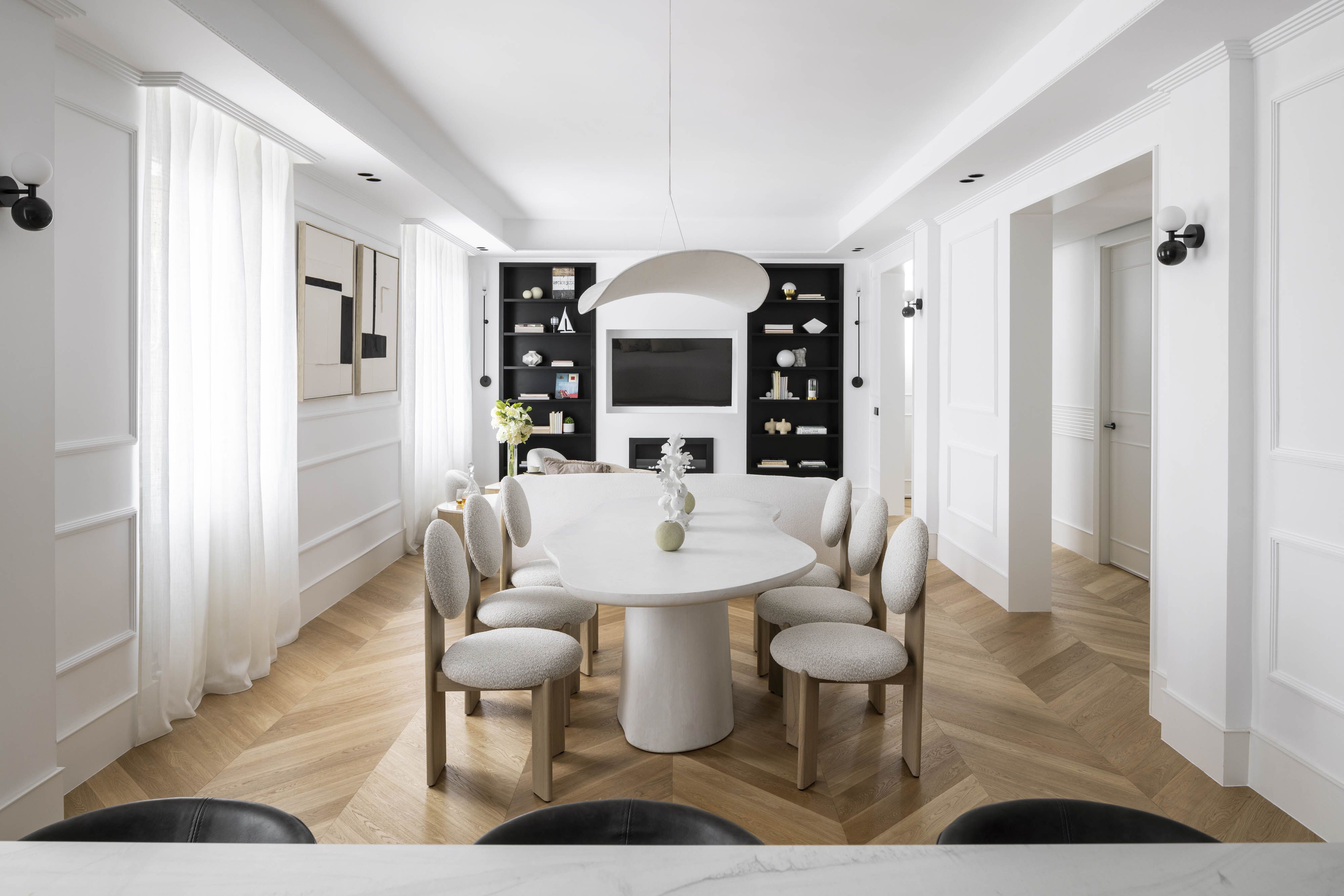 Comedor abierto diseñado por el estudio Alberto Torres con tonos neutros, mobiliario orgánico y continuidad visual para reducir el ruido visual en casa.