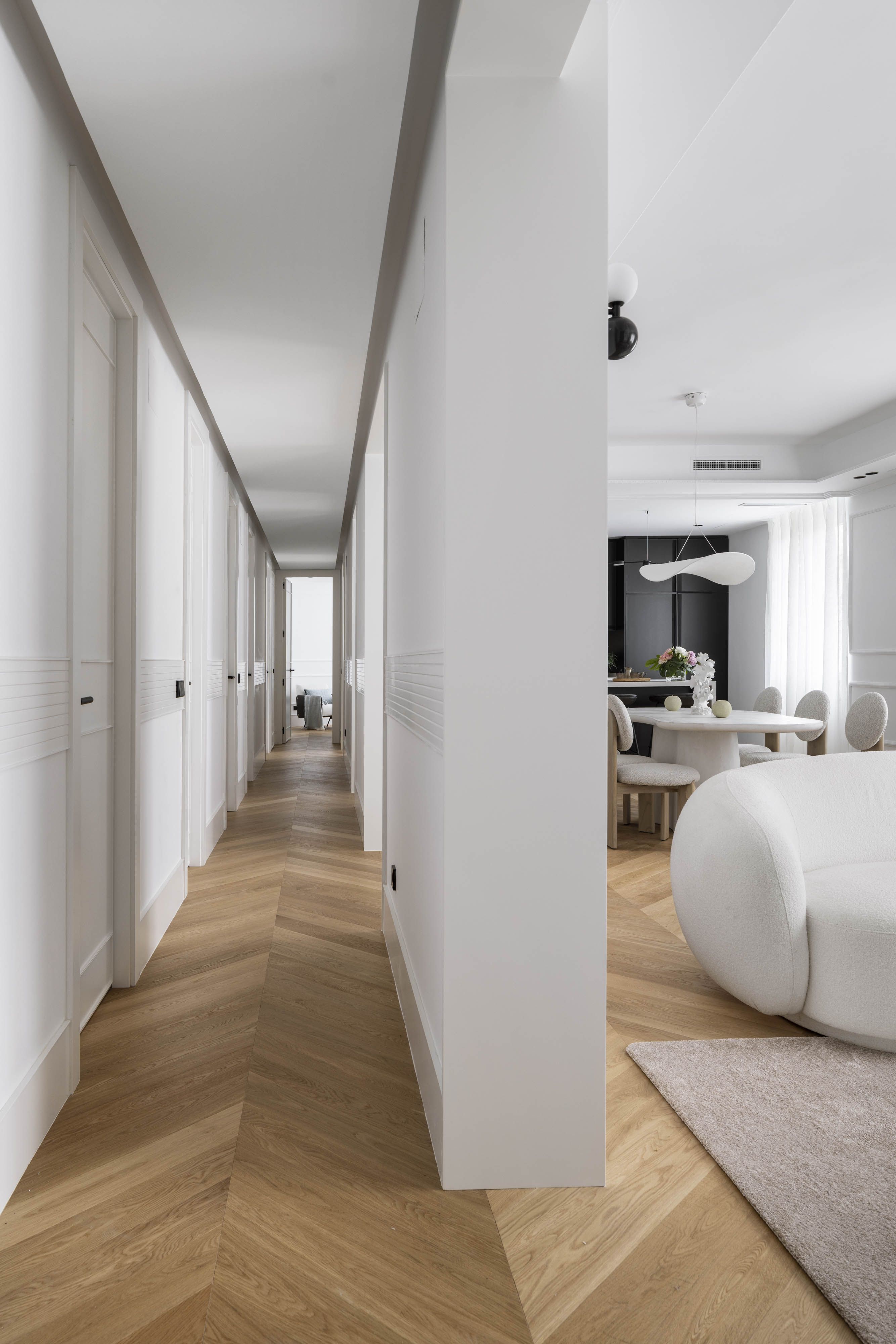 Pasillo con continuidad visual diseñado por el estudio Alberto Torres para reducir el ruido visual en casa y potenciar la sensación de amplitud.