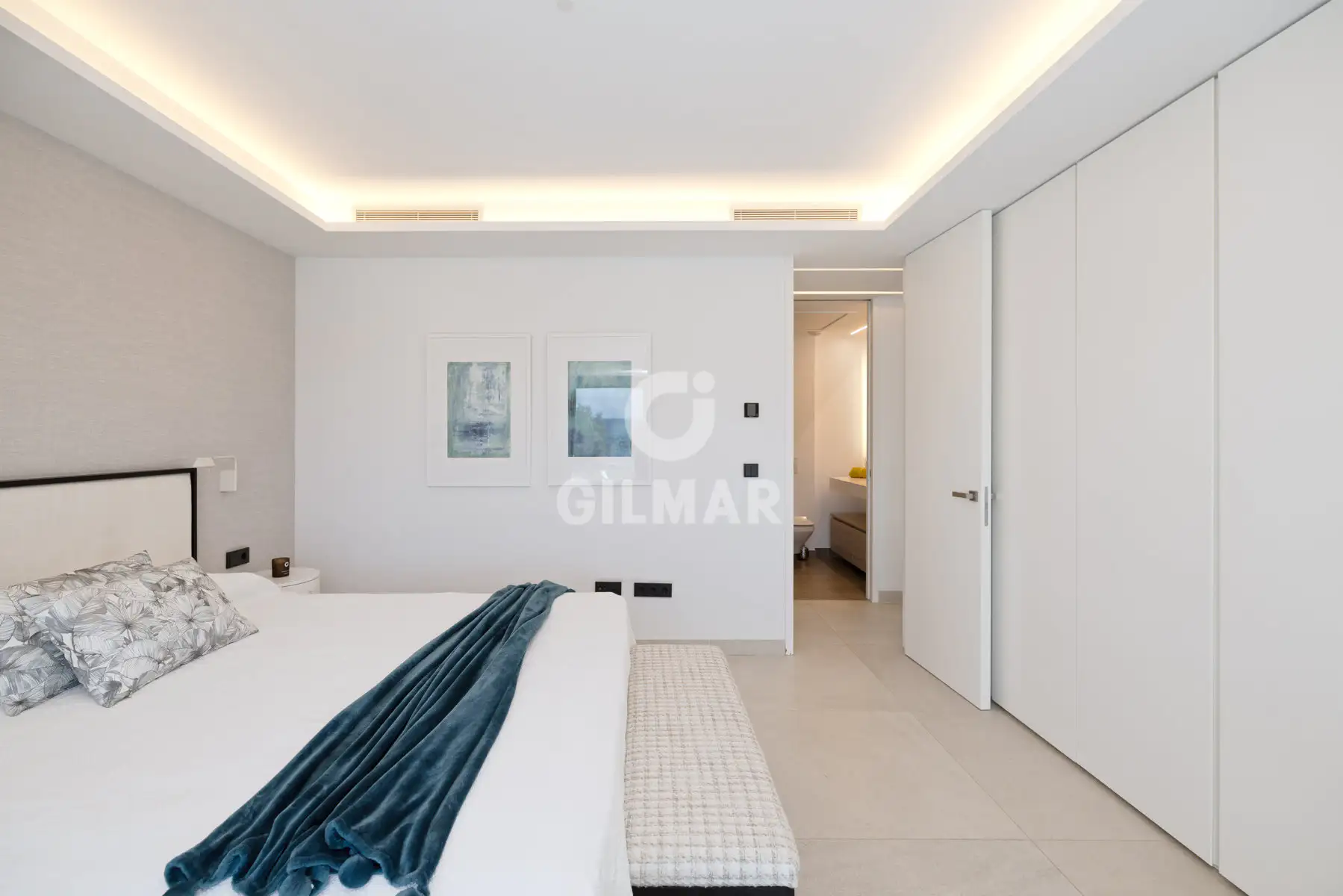 Dormitorio principal en suite con baño integrado y armarios empotrados en casa frente al mar en Estepona