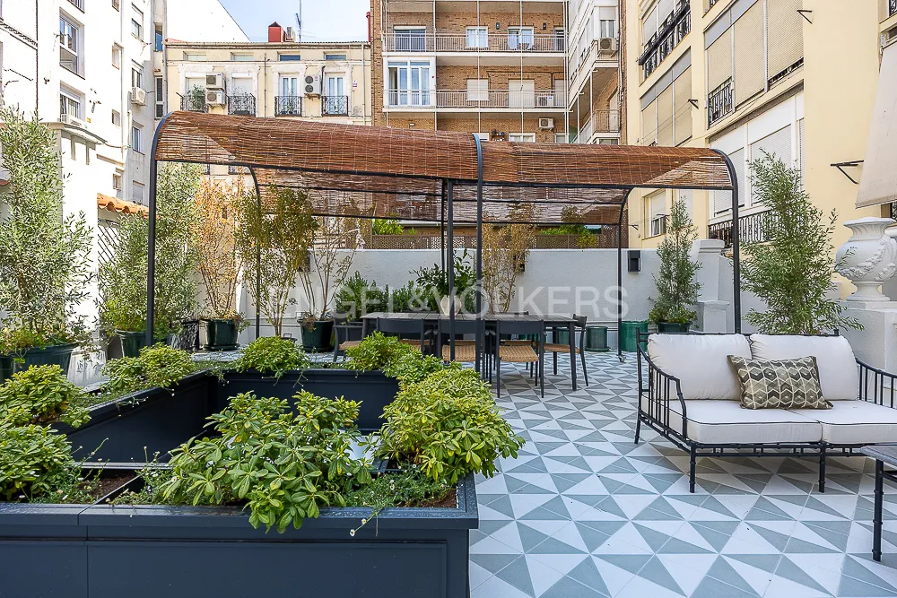 Terraza con pérgola y comedor exterior en una casa junto a El Retiro en Recoletos, Madrid